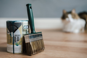A close-up of a paintbrush next to a can of paint.