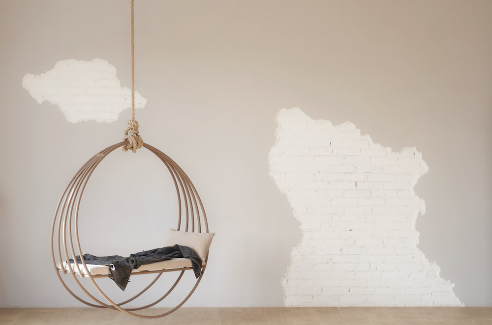 A hanging chair in front of a half-painted wall by painters in Riverside County