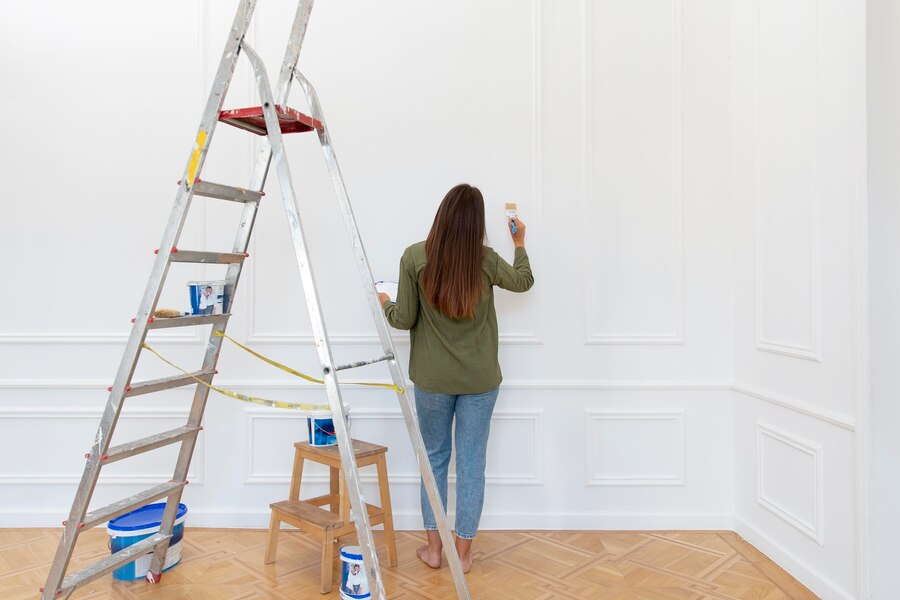 full-shot-woman-painting-wall_23-2149098982