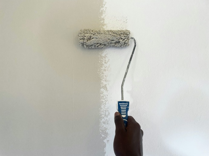 exterior house painter in Riverside County using a paint roller to paint a wall