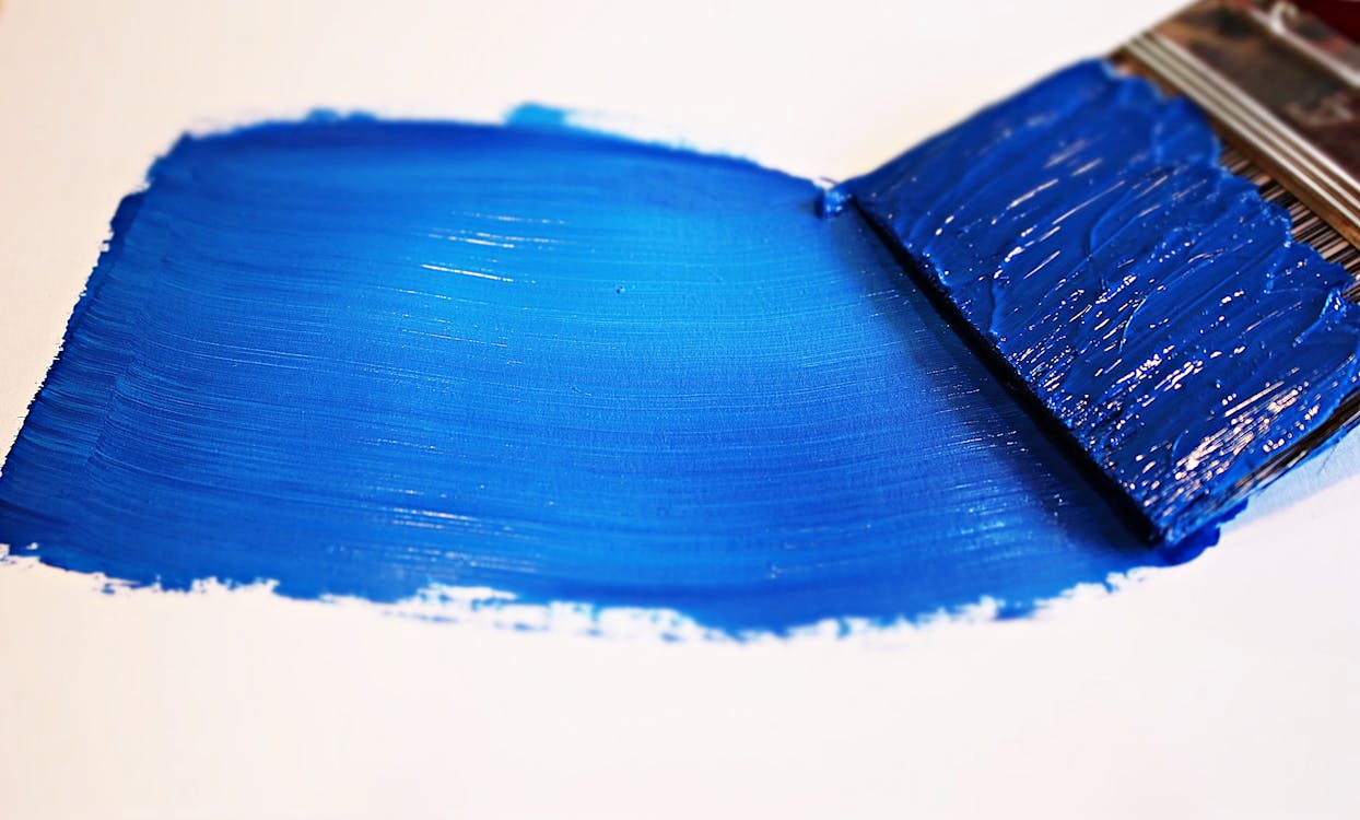 A bold stroke of blue paint on a white surface