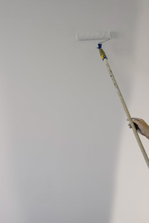 A person using a paint roller to refresh an interior wall