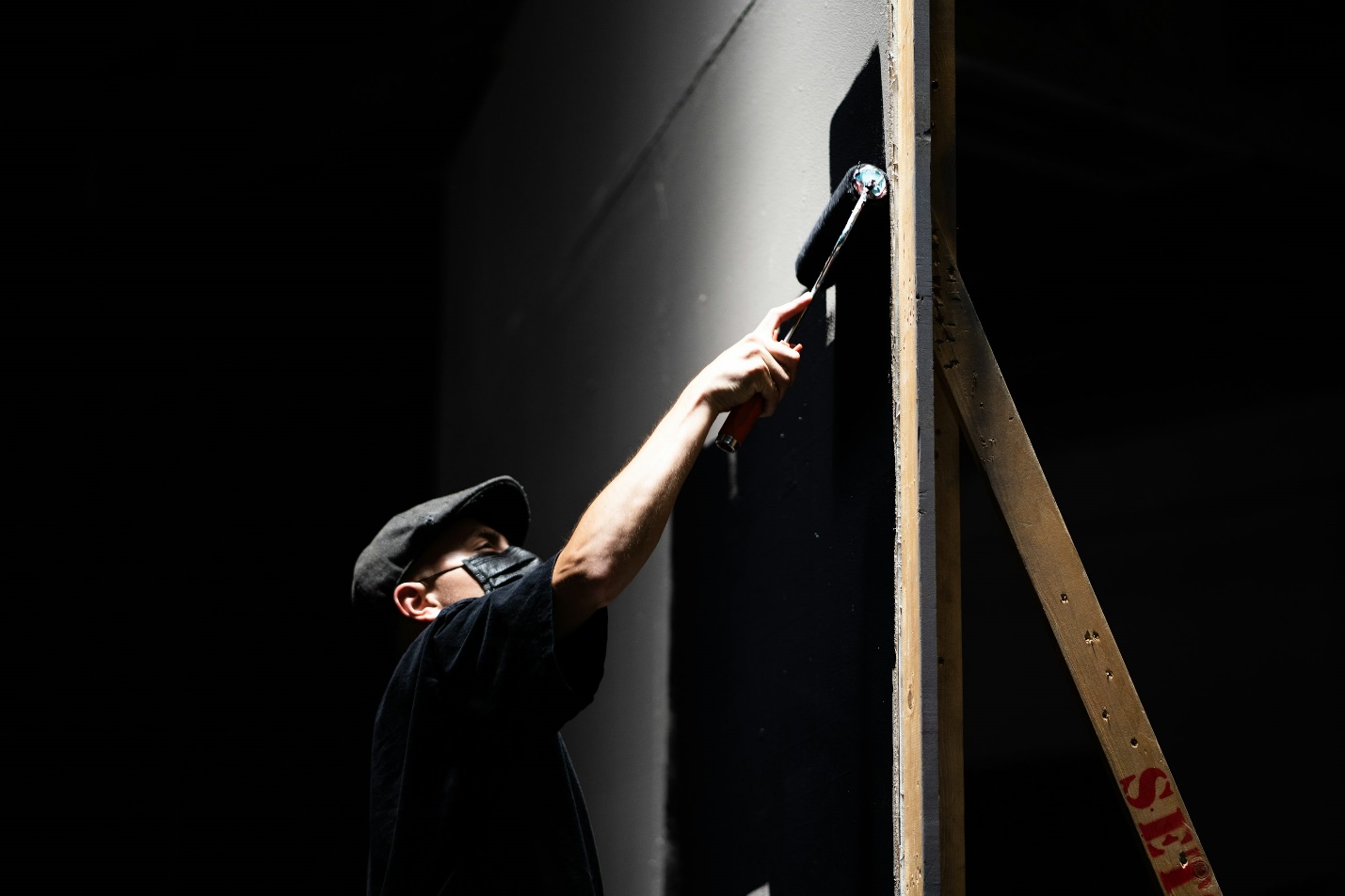 A person painting a wooden wall with a brush