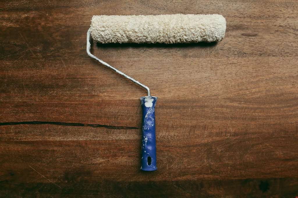 a paint roller on a wooden surface.