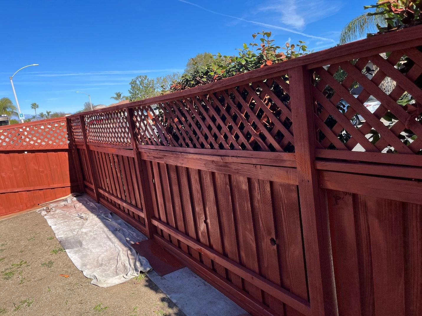 a freshly painted fence surrounding a residence