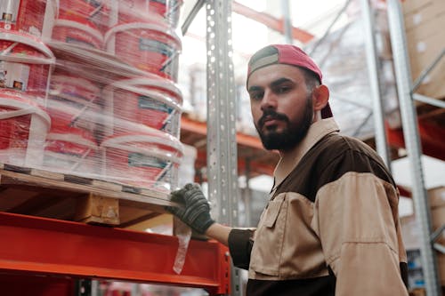 A person standing with boxes of paint supplies.