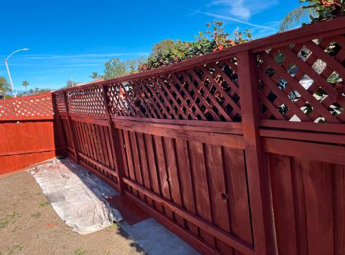 A backyard fence with a clean, even coat of paint, perfectly matched to the home’s exterior colors.