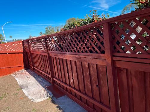 A freshly painted fence enhances the outdoor aesthetic of a home, providing a neat and vibrant look.