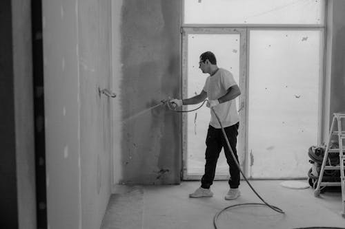 Professional commercial painter applying paint to an interior wall to elevate a business’s appearance.