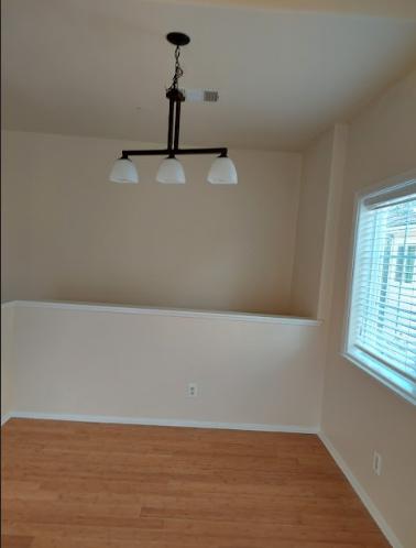 a room with a window and pendant lights.