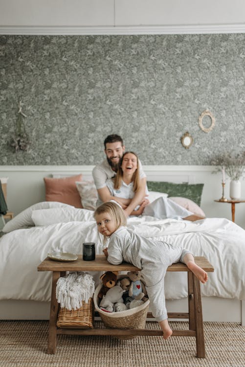 a child with her parents in the bedroom.