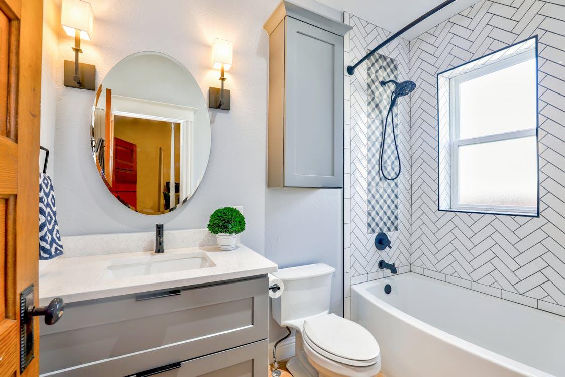 an oval mirror in a modern bathroom space.