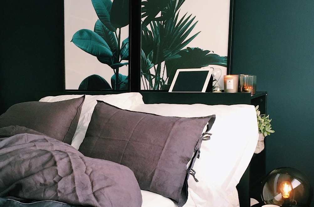 Green leaf paintings behind a bed
