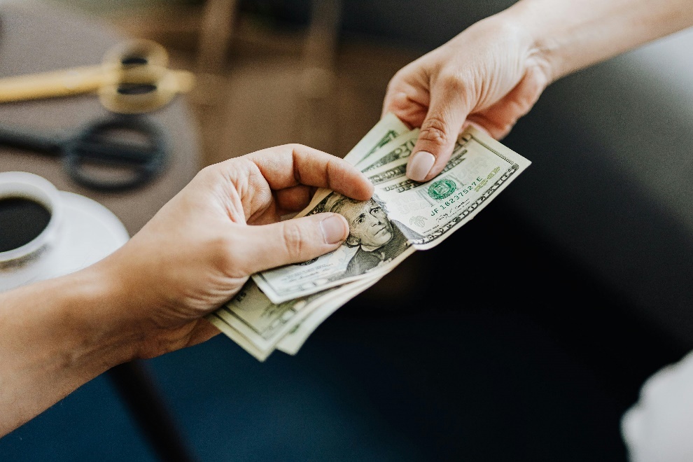 Hands exchanging dollar bills 